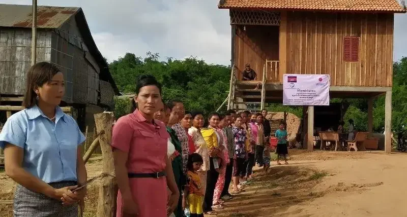 Families about to receive a new or rehabilitated house in Tboung Khmum, Cambodia welcome delegates to the official handover ceremony